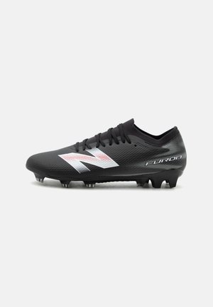 Chaussure de football noire avec logo latéral blanc et rouge, lacets et crampons moulés conçus pour jouer sur terrain ferme.