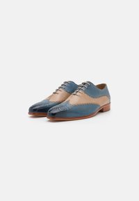 Scarpe in pelle blu e beige con punta affilata, perforazioni decorative e finitura liscia. Design classico con lacci e suole marroni.