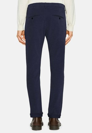 Pantalon marine à coupe ajustée, avec poches arrière à boutons, ourlets à revers et une texture de tissu lisse.