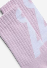 Roze geribbelde sokken met een wit logopatroon, gemaakt van een zachte stof met een gladde textuur en afgewerkte boorden voor comfort.