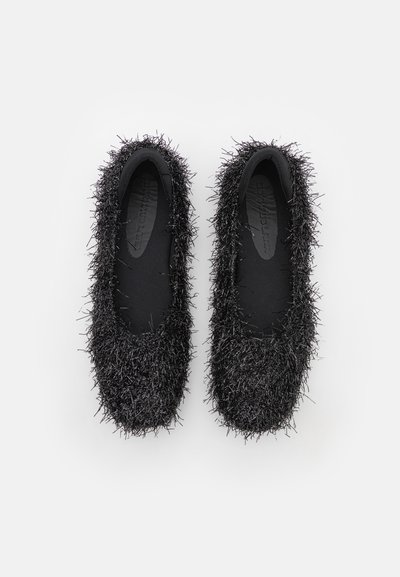 Black flat shoes covered in soft, fuzzy material. Features a rounded toe and smooth interior lining. Lightweight and flexible design.