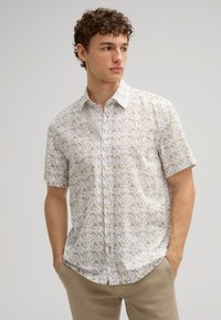 Kurzarm-Hemd mit Knopfleiste in hellem Beige mit floralem Muster. Verfügt über einen klassischen Kragen und einen dezent strukturierten Stoff.