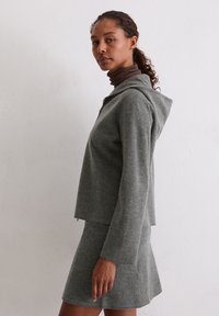 Grijze, geknipte hoodie van zacht stof met een rits, gecombineerd met een bijpassende minirok. Heeft een relaxte pasvorm en een capuchon.