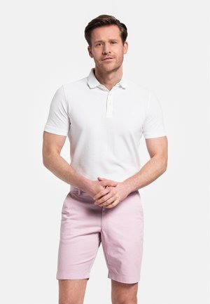 Witte polo met kraag en korte mouwen, gecombineerd met lichtroze shorts. Glad textuur, getailleerd ontwerp en vlakke voorkant.