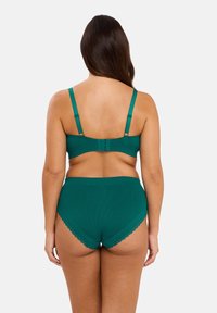 Bralette en teal avec des bordures en dentelle et culotte haute. Tissu doux, texture côtelée, bretelles réglables et fermeture à crochets à l'arrière.