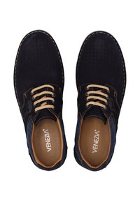 Dark blue suede shoes with perforated design, beige laces, contrasting stitching, and textured accents on the sides. Brand name visible inside.