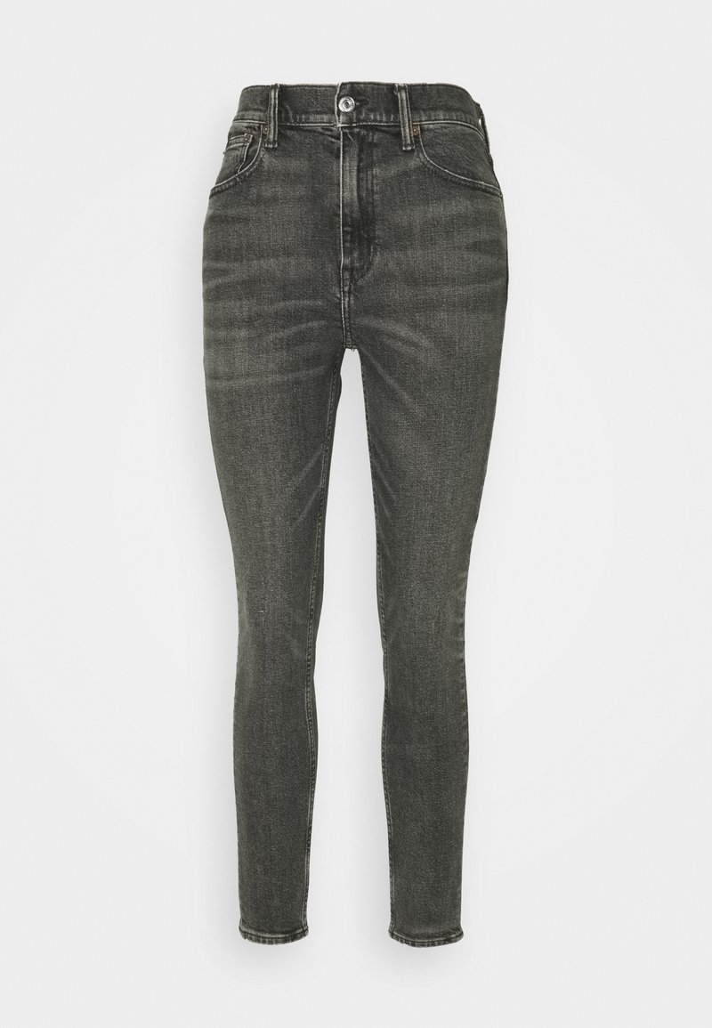 Jean skinny noir taille haute avec bouton avant, fermeture éclair et design cinq poches, présenté sur un fond clair.