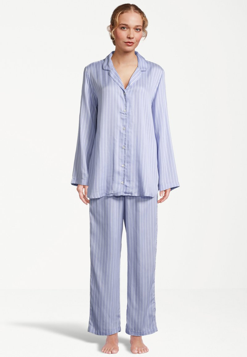 Ljust blå randig pyjamasuppsättning av mjukt tyg. Överdelen har en krage och knappstängning; byxorna är löst sittande med elastisk midja.