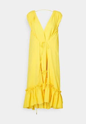 Żółta sukienka z dekoltem w kształcie litery V, drapowany materiał i falbaniasty dół. Posiada regulowane wiązania w talii i na ramiączkach, gładka tekstura.
