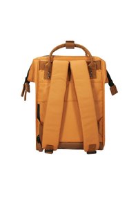 Orangenes Rucksack mit rechteckigem Design, ausgestattet mit gepolsterten Schultergurten, einem oberen Tragegriff und seitlichen Reißverschlusstaschen zur Aufbewahrung.