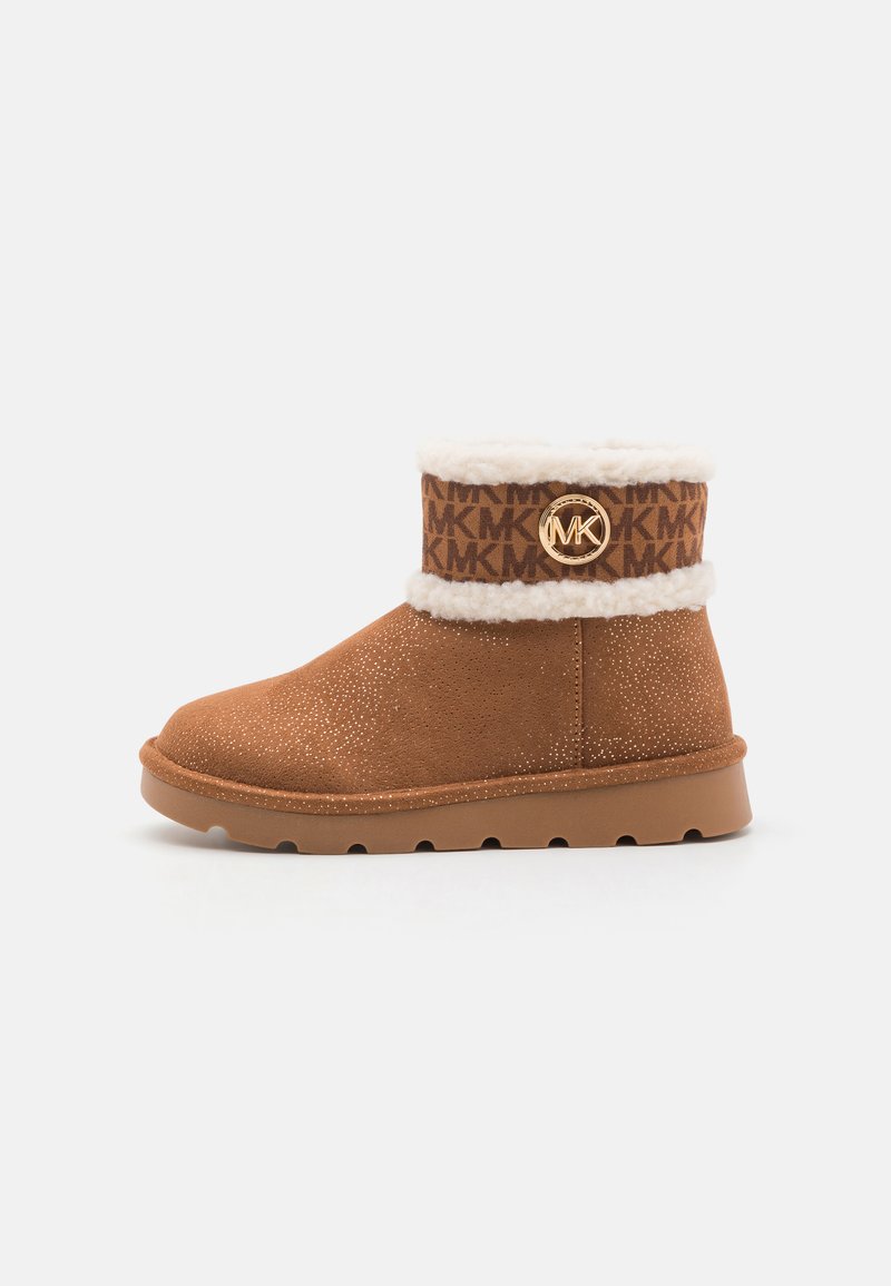 Brown suede ankle boot with a cozy white fleece lining. Features a logo band around the cuff and a textured, non-slip sole.