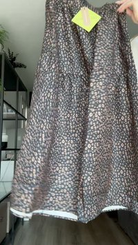 Black and pink leopard print dress with a flowing silhouette, gathered neckline, and a white hem detail at the bottom.