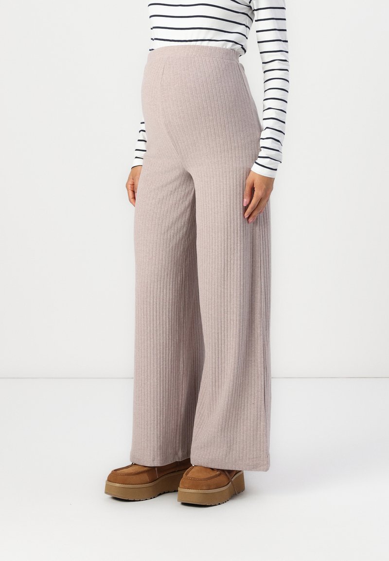 Helle pinke, gerippte, weit geschnittene Hosen mit hohem Bund, aus weichem Stoff, kombiniert mit braunen Plateauschuhen und einem gestreiften Langarmshirt.