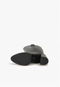 Czarny skórzany botek za kostkę z zaokrąglonym noskiem i niskim obcasem. Podeszwa jest teksturowana, z oznaczeniem rozmiaru "37" na spodzie.