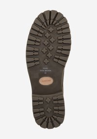 Semelle en caoutchouc marron foncé avec des motifs de bande de roulement profonds, comportant des formes rectangulaires et croisées pour l’adhérence. Comprend un accent en cuir de marque.