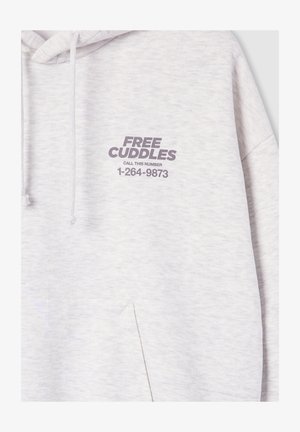 Jasnoszara bluza z kapturem z napisem "DARMOWE PRZYTULENIA ZADZWOŃ POD TEN NUMER 1-264-9873" wydrukowanym na lewej klatce piersiowej nad kieszenią.