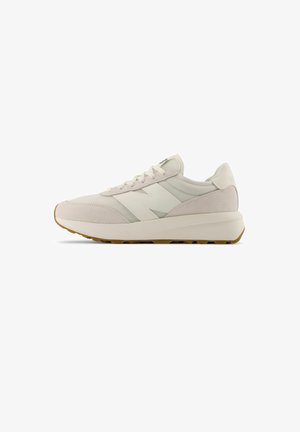 Suede and mesh sneaker in light beige with a white logo and gum outsole. Features flat laces and a smooth, rounded silhouette.