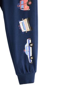 Marineblå joggingbukser med trykte illustrationer af tre redningskøretøjer: en rød brandbil, en hvid ambulance og en blå politibil.