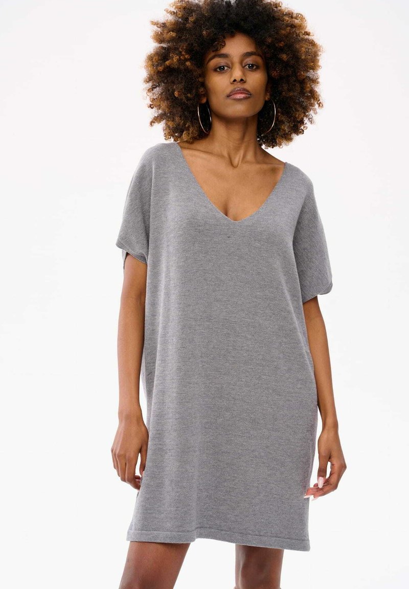 Szara sukienka z krótkim rękawem i dekoltem w serek, wykonana z miękkiego materiału, charakteryzująca się luźnym krojem i prostym dołem.