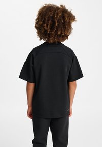 Sort bomulds t-shirt med korte ærmer og rund hals, med et enkelt design og uden synlige mønstre eller accenter.