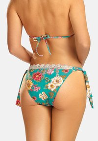 Bikini o kwiatowym wzorze w odcieniu turkusowym z białą koronką. Posiada regulowane sznurki po bokach oraz gładką, błyszczącą teksturę.