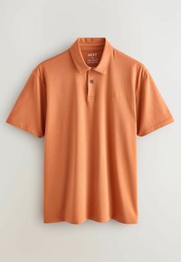 Oranssi poolopaita, joka on valmistettu sileästä puuvillasta. Paidassa on kaulus, lyhyet hihat, kolme nappia edessä ja pieni brodeerattu logo.