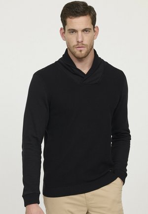 Pull en tricot noir avec un col châle et des poignets côtelés. Le design comprend un tissu texturé avec des manches longues et une coupe décontractée.