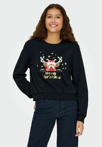 Melns sporta krekls ar ziemeļbriedi grafiku, antlers, sarkanu degunu un mirdzošu tekstu "Priecīgus Ziemassvētkus". Mīksta auduma, brīva piegriezuma.