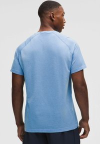 Hellblaues kurzärmeliges Sportshirt mit strukturiertem Muster, rundem Halsausschnitt und Raglanärmeln. Hergestellt aus atmungsaktivem Material.