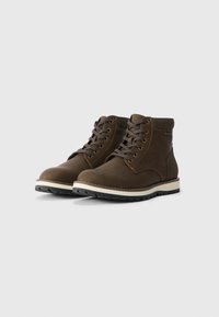 Brown leather mid-top boots with round toe, lace-up design, contrasting white midsole, and textured black rubber outsole.