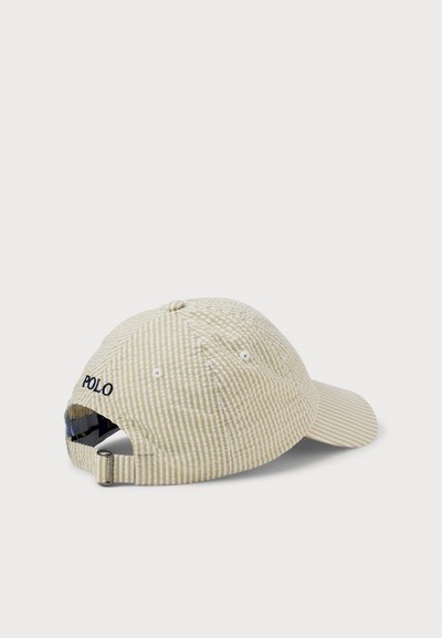 Șapcă din bumbac bej cu dungi, cozoroc curbat, detalii cusute și o curea reglabilă în spate cu o cataramă metalică. Logo-ul "POLO" brodat.