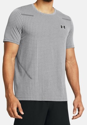 Mężczyzna ubrany w szarą sportową koszulkę z krótkim rękawem, z drobnym wzorem w kratkę i czarnym logo Under Armour na piersi.