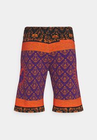 Lila shorts med intrikata orange och svarta mönster, med ett dekorativt elastiskt midjeband och tryckdetaljer på benen.