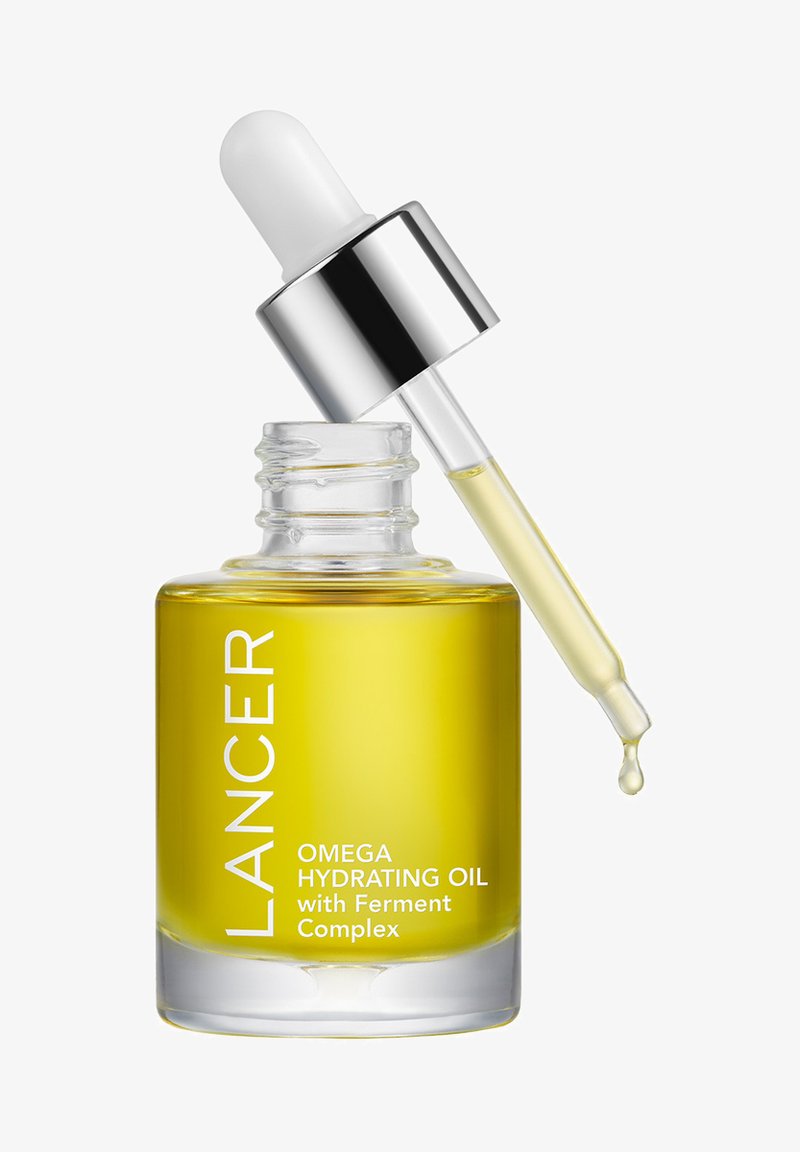 Klare Glasflasche mit rundem Boden, gefüllt mit gelbem Öl. Silberner Pipettenverschluss mit einer weißen Blase und Branding-Text auf der Vorderseite.