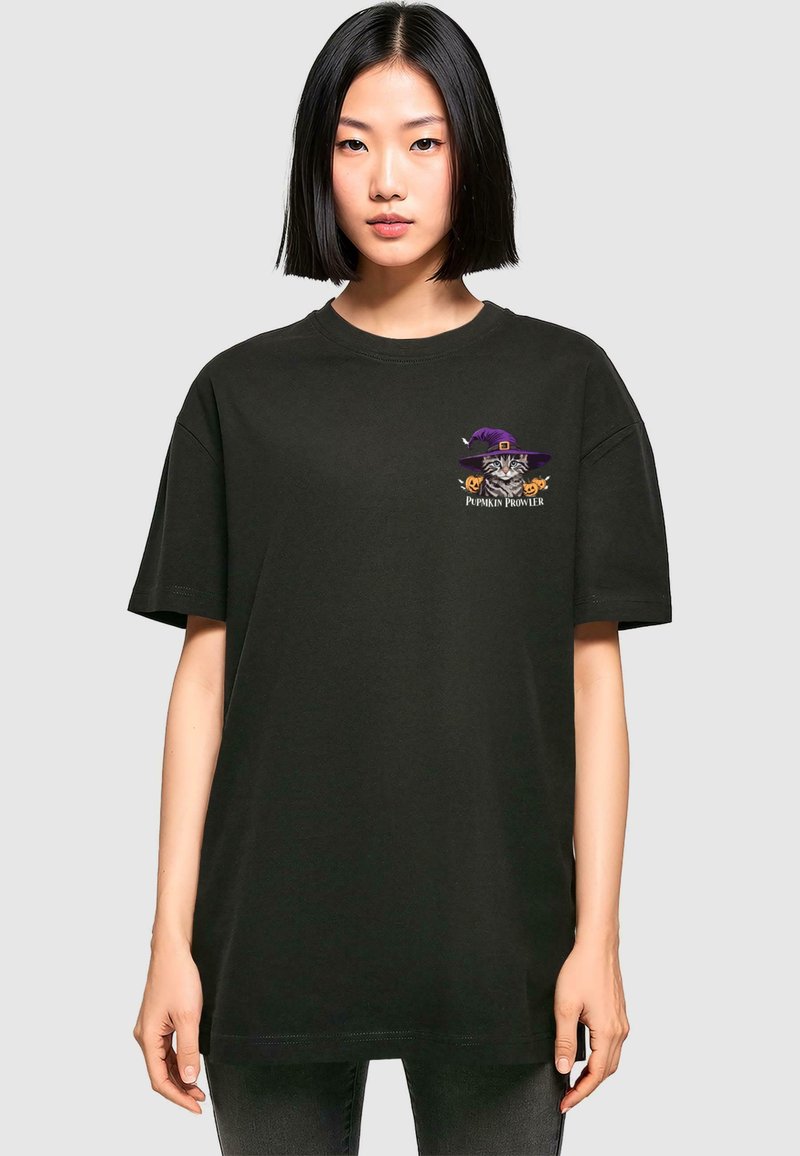 Sort kortærmet t-shirt lavet af bomuld, der har et farverigt grafisk motiv af en kat med en lilla hat og græskars detaljer på brystet.