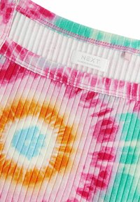 Farverigt tie-dye stof i nuancer af pink, orange og lys blå med en ribbet tekstur og et label, der siger 'NEXT, MADE IN BANGLADESH.'