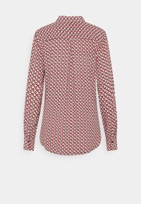 Chemise à manches longues présentant un motif multicolore de formes entrelacées, avec un col et des détails de boutons au dos. Le tissu semble lisse.