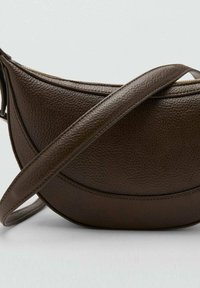 Brązowa skórzana torba o zakrzywionym kształcie, fakturowanej powierzchni oraz długim, regulowanym pasku. Posiada zamek błyskawiczny wzdłuż górnej krawędzi.