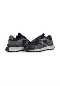 Black and gray sneakers featuring a mix of smooth and textured materials, a prominent zigzag pattern, and a rubber sole with tread.