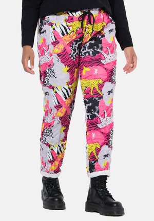 Colorful jogger pants featuring a mix of animal prints and vibrant patterns in pink, yellow, and black, with a drawstring waist and cuffed hems.
