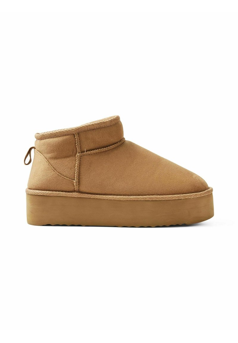 Botas de tobillo de ante color tostado con puntera redondeada, cuello bajo y suela de goma gruesa con un borde texturizado. Tirador trasero para facilitar el calzado.