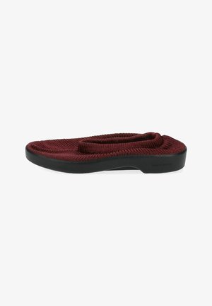 Zapato de punto rojo tipo slip-on con punta redondeada, parte superior elástica y suela de goma negra. Presenta una parte superior texturizada.