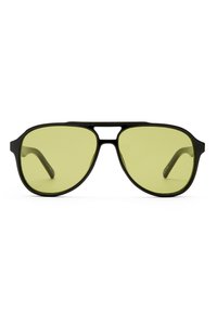 Mαύρα αεροπόρικα γυαλιά ηλίου με κίτρινους φακούς, σε μαύρο πλαίσιο, εμφανιζόμενα από μπροστά σε λευκό φόντο.