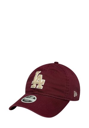 Maroon baseball cap with a beige "LA" embroidered logo. Features a curved brim and adjustable strap on the back. Made of cotton.
