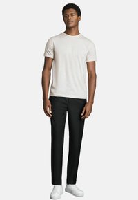 Tricou scurt de culoare gri deschis, purtat cu pantaloni negri tailored și adidași albi. Design simplu, cu o croială lejeră și textură netedă.
