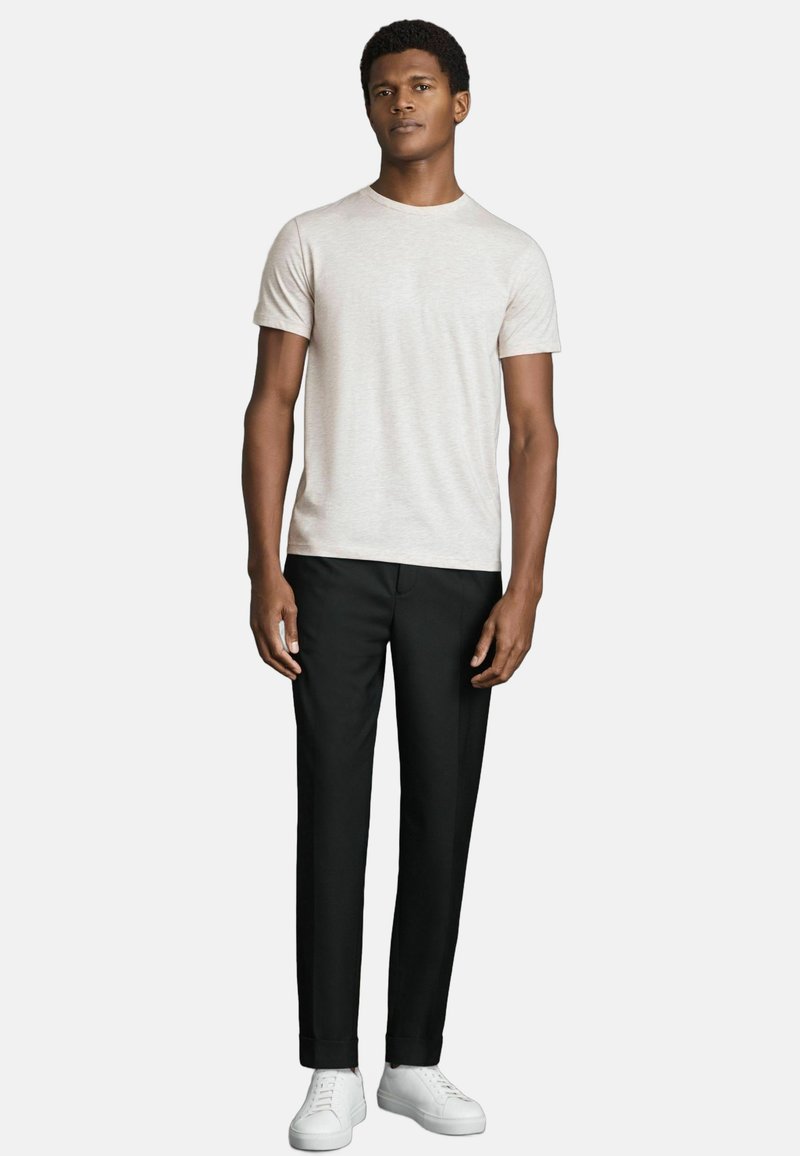 Tricou scurt de culoare gri deschis, purtat cu pantaloni negri tailored și adidași albi. Design simplu, cu o croială lejeră și textură netedă.