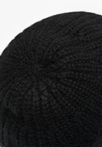 Black knit beanie with a textured pattern and rounded top, made from soft wool or acrylic material, featuring a subtle sheen.