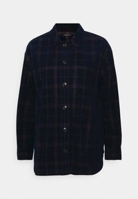 Camicia flanella a quadri blu navy con apertura frontale a bottoni, colletto e maniche lunghe. Presenta bottoni scuri e sottili accenti rossi e verdi.
