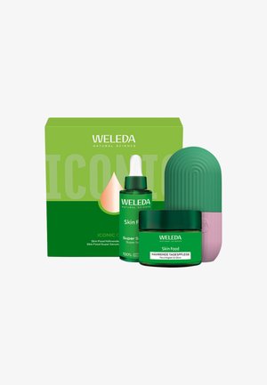 Weleda Skin Food set met groene doos, druppelflesje, crèmepotje en tweekleurige groen-roze gestructureerde applicator.