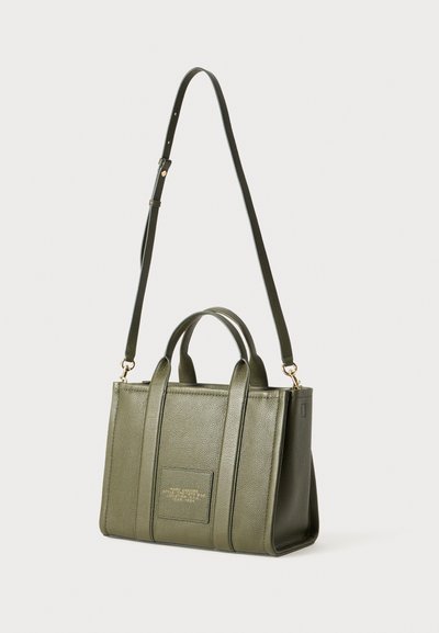 Olijfgroene leren tote bag met dubbele handvatten aan de bovenkant en een afneembare schouderband. Beschikt over een textuurafwerking en een gouden logo-detail aan de voorkant.